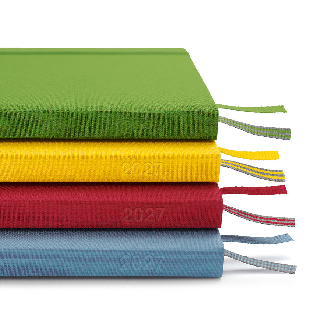 Four colorful diaries stacked on a white background, each with '2027' printed on them.