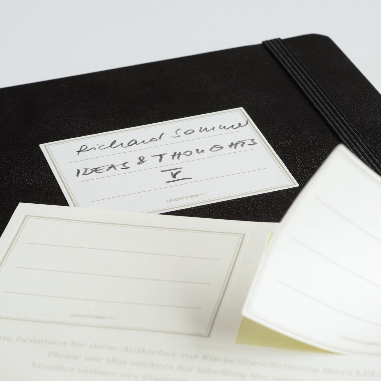 Black notebook with white label on a light gray background.