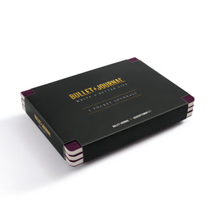 Bullet Journal 3 Pocket 100 Pages notebook set in a sleek black box with gold lettering and purple corner accents, photographed on a clean white background.
