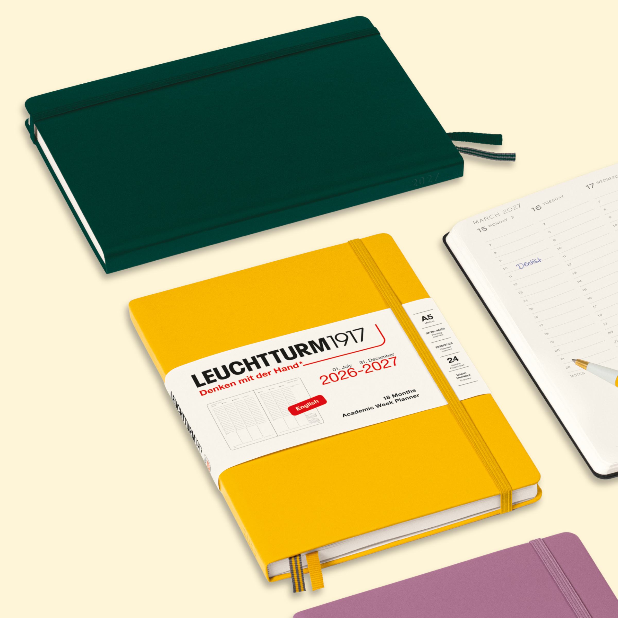 A Leuchtturm1917 2028-2027 daily planner shown in a bright yellow cover with a white paper band label, alongside other planner views and covers including dark green and purple on a pale cream background.