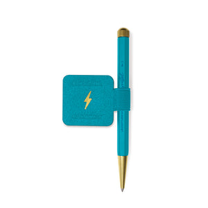 A teal and gold ballpoint pen with a matching teal square card holder featuring a gold lightning bolt logo, displayed on a clean white background.