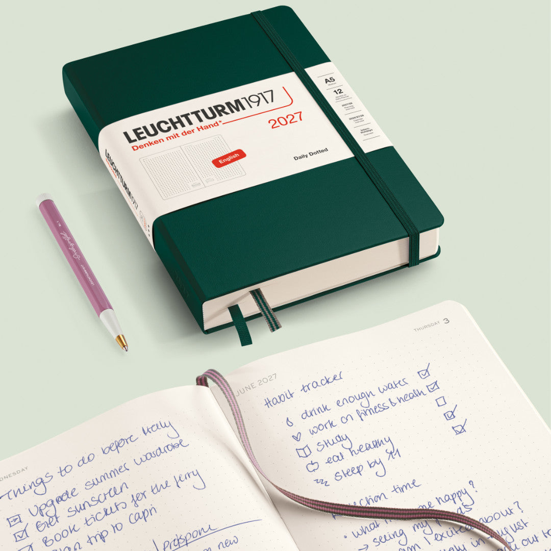 Green Leuchtturm1917 notebook with a pen on a light green background
