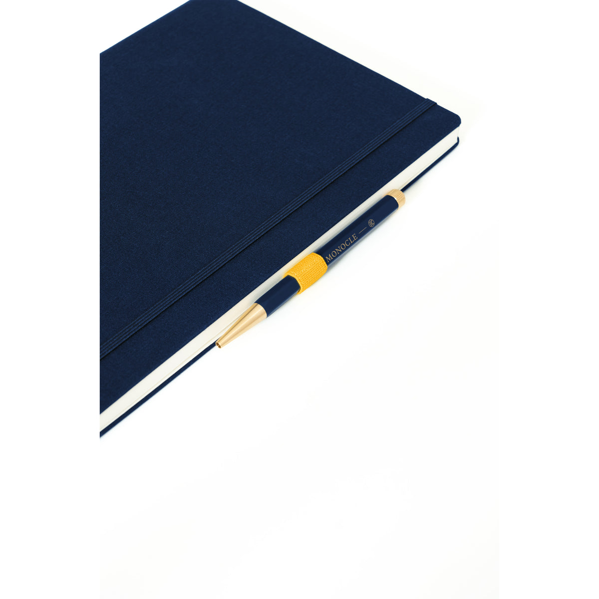 A dark navy blue hardcover notebook with a matching elastic closure, shown at an angle with a black and yellow pen resting on top, against a clean white background.