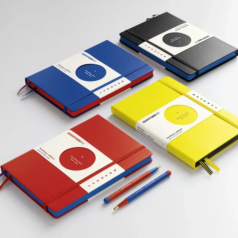 Four colorful notebooks with pen holders on a white background