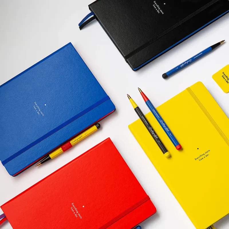 Colorful notebooks and pens on a white background