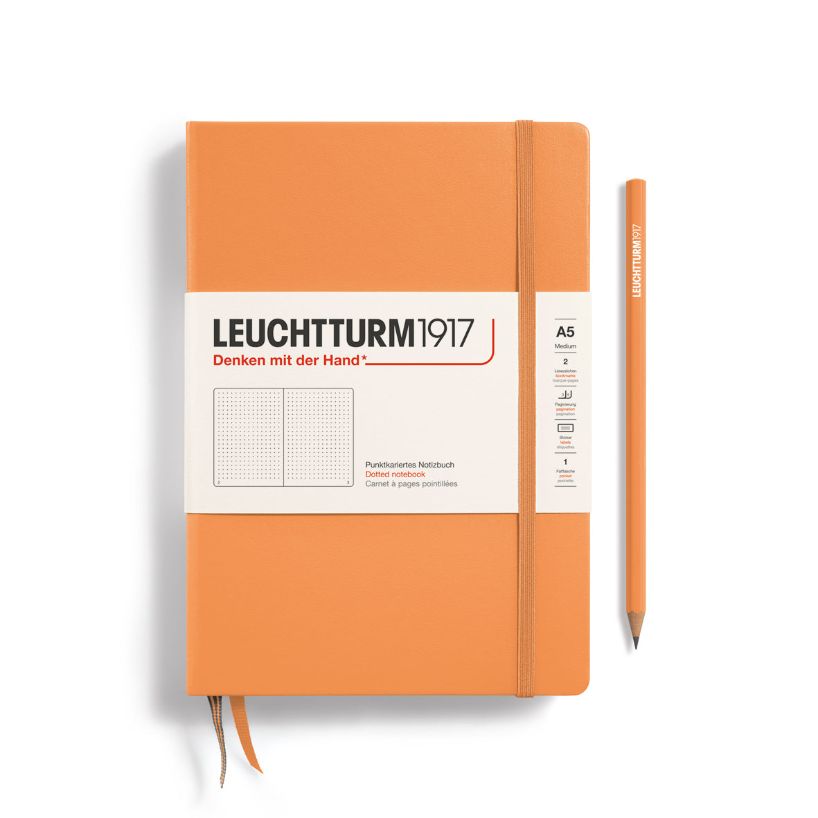 An orange Leuchtturm1917 A5 notebook with a white paper band around the middle and a matching orange pencil, shown on a clean white background.