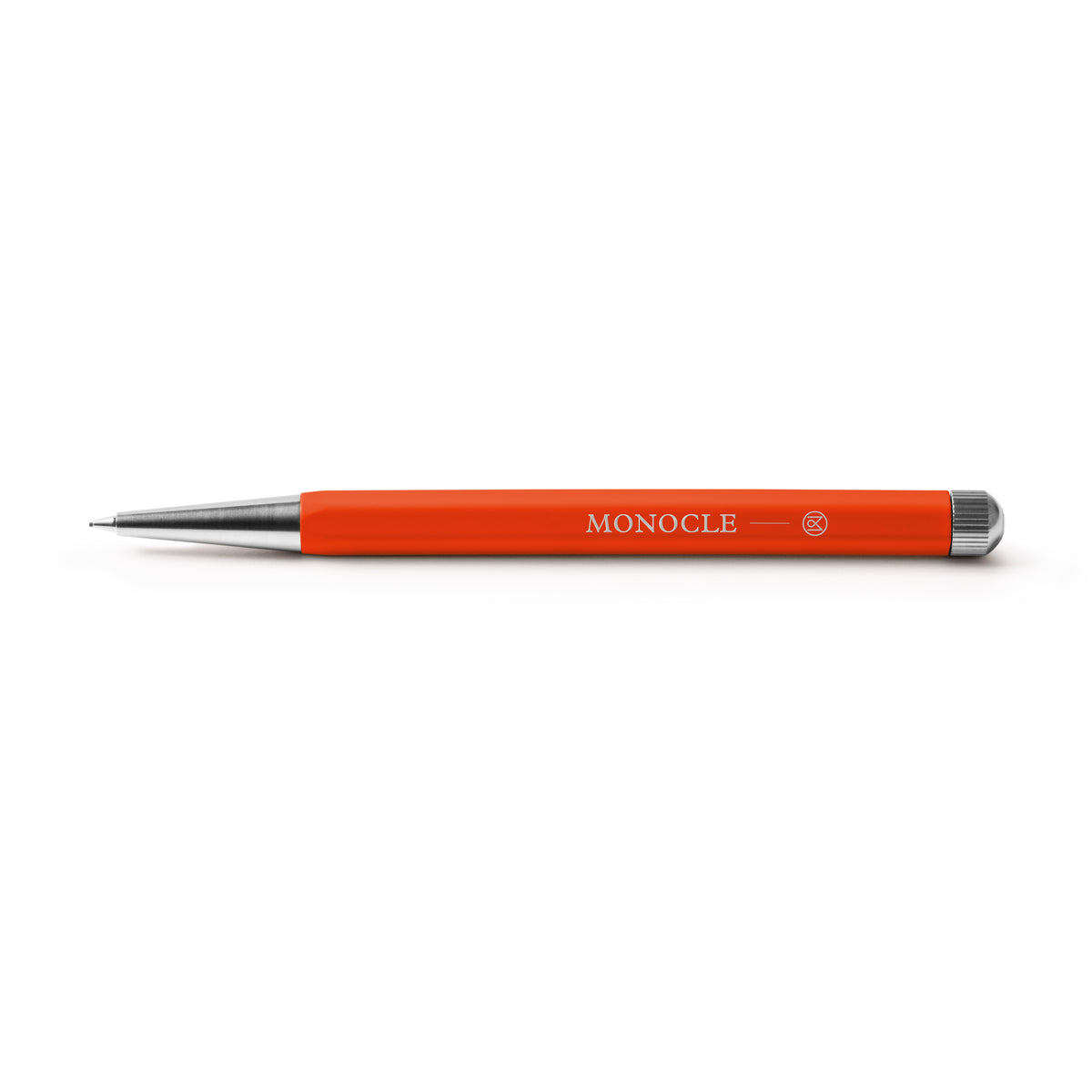An orange retractable pen with silver metal accents and the brand name 'MONOCLE' printed in white on the barrel, shown against a plain white background.