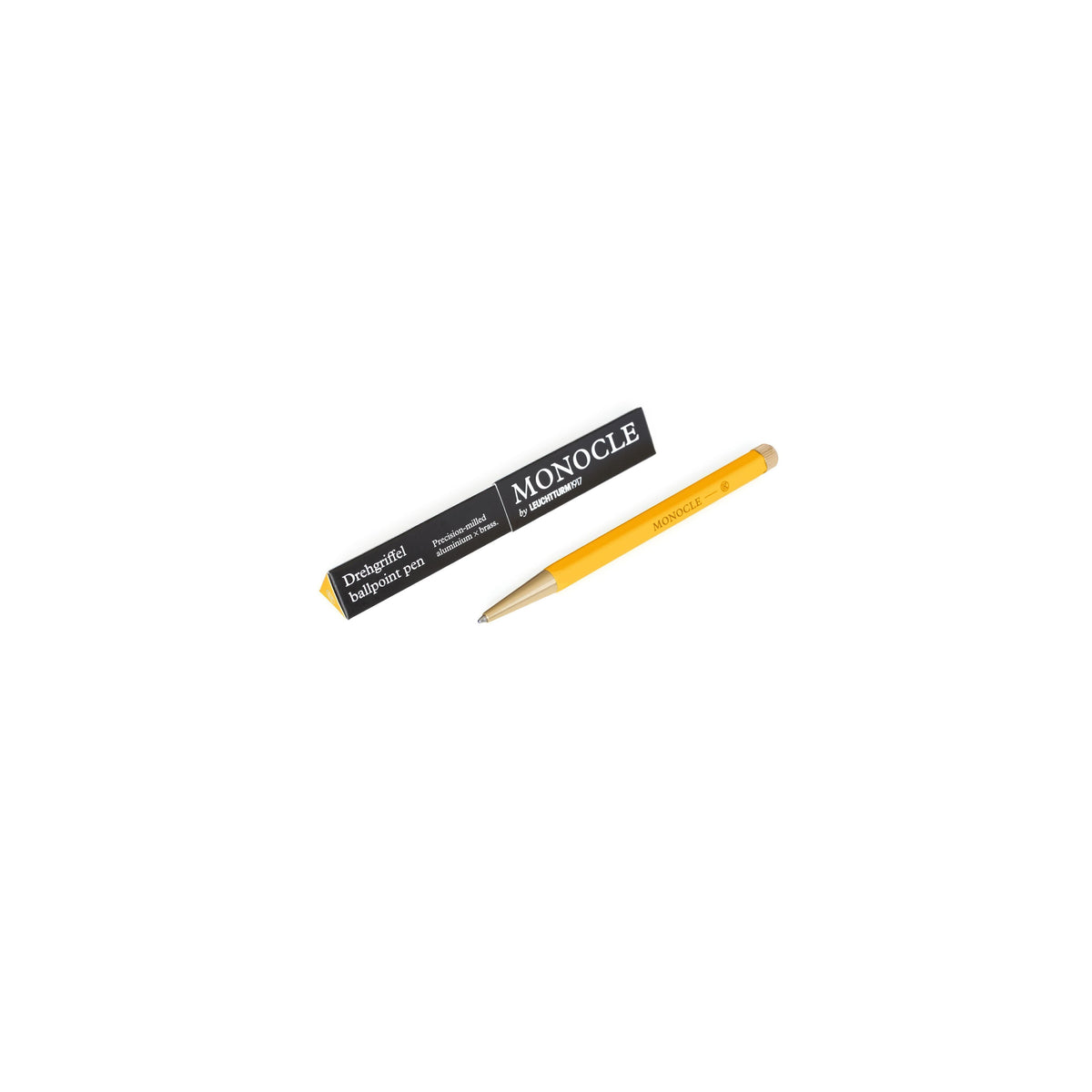 A yellow Monocle marking pencil next to its black and yellow packaging box, displayed on a clean white background.
