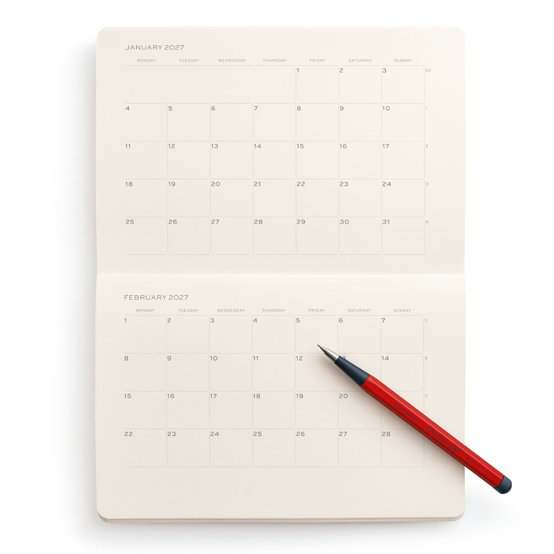 Calendar notebook with a red pen on a white background