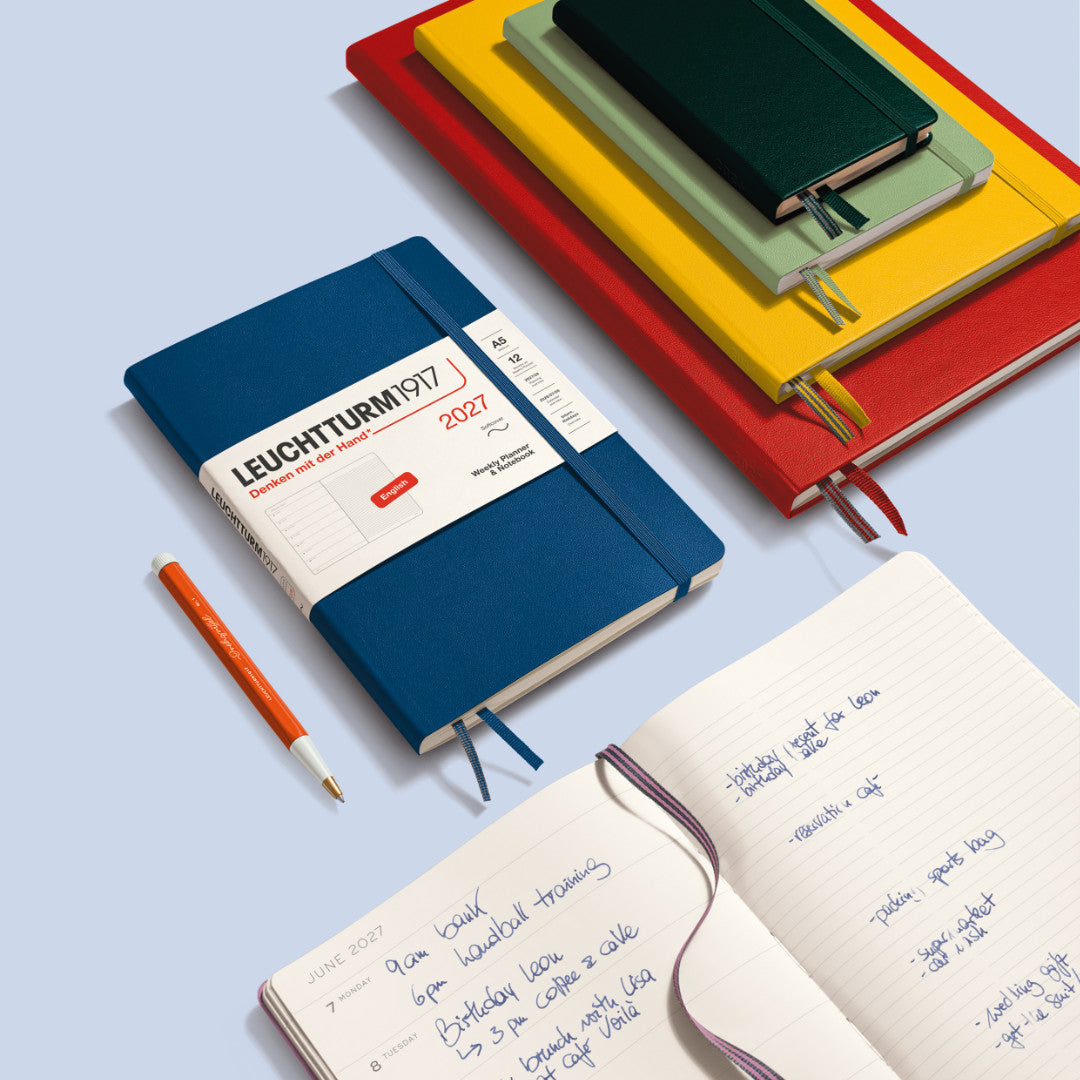 Colorful notebooks with a pen on a light blue background, featuring Leuchtturm1917 branding.
